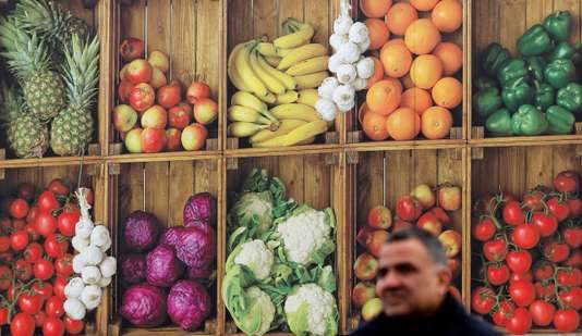 A man walks past a Nisa Grocers delivery lorry with fruit and vegetable livery in Wolverhampton